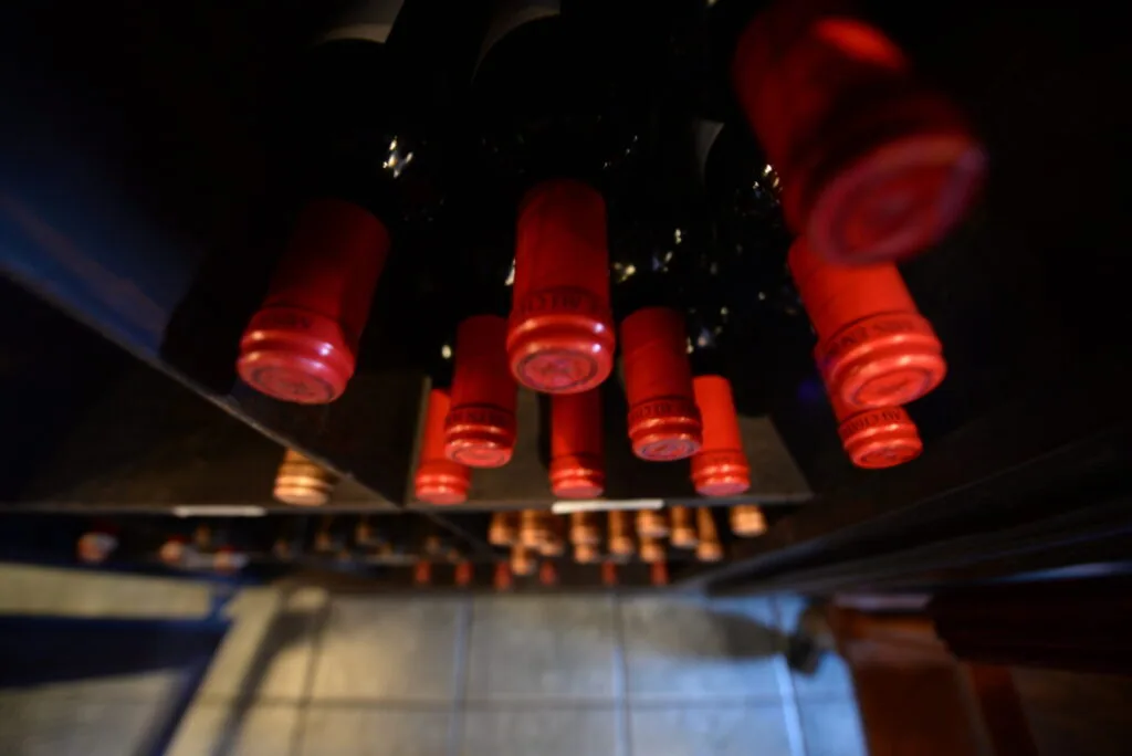 Glowing red cylindrical lamps hanging against dark ceiling with blurred background