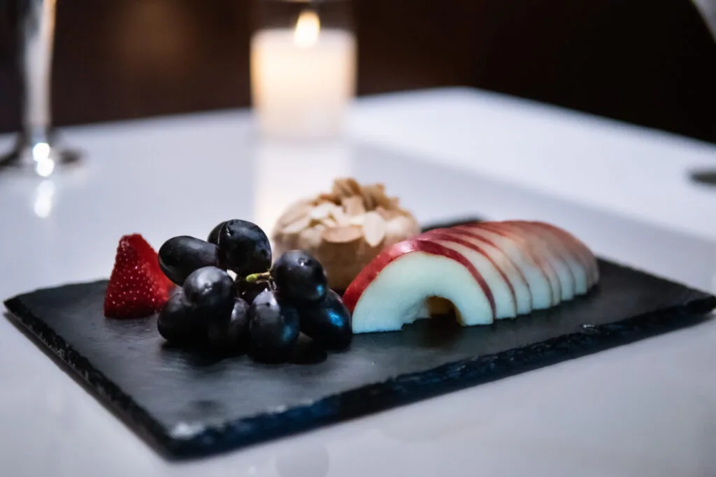 A cheese and fruit plate on slate